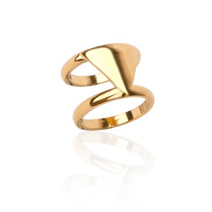 Peut inclure: Une bague en or avec un design géométrique. La bague est composée de deux bandes reliées par une forme triangulaire.