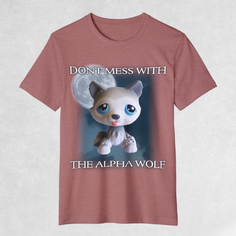 May include: A pink t-shirt with a cartoon wolf in front of a full moon. The text "DON'T MESS WITH THE ALPHA WOLF" is printed on the shirt.