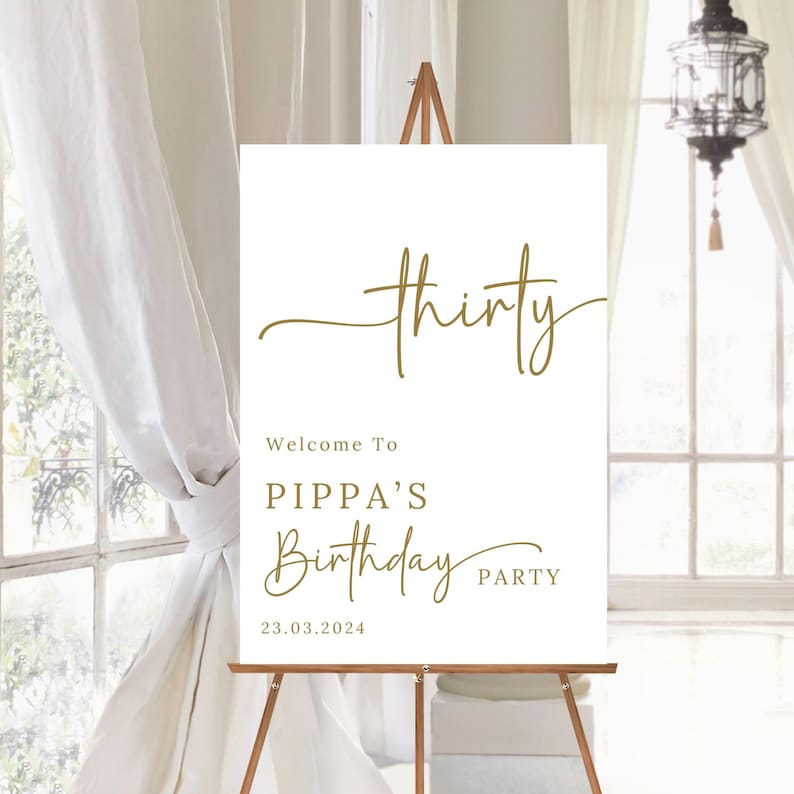 May include: A white sign on a wooden easel with gold text that reads "thirty". Below it says "Welcome To PIPPA'S Birthday PARTY" and the date "23.03.2024". The sign is in front of a window with white curtains.