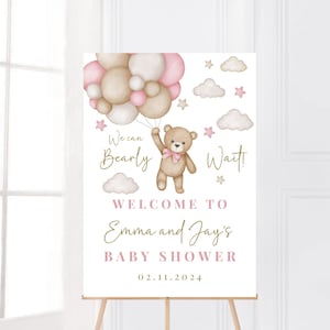 K&ouml;nnte beinhalten: Ein Willkommens-Schild f&uuml;r eine Babyparty mit einem Teddyb&auml;ren, der rosa und braune Ballons h&auml;lt. Das Schild lautet "We can bearly wait! Welcome to Emma and Jay's Baby Shower 02.11.2024"