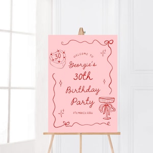 K&ouml;nnte beinhalten: Ein rosa Geburtstagsparty-Schild auf einer Staffelei. Das Schild hat roten Text und Illustrationen, darunter ein Kuchen, Sterne und eine dekorative Bord&uuml;re. Der Text lautet "Willkommen zu Georgies 30. Geburtstagsparty 7. M&auml;rz 2026."
