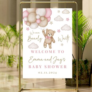 K&ouml;nnte beinhalten: Ein wei&szlig;es Babyparty-Schild mit einem Teddyb&auml;ren, der rosa und braune Ballons h&auml;lt. Auf dem Schild steht "We can Bearly Wait! Welcome to Emma and Jay's Baby Shower 02.11.2024".