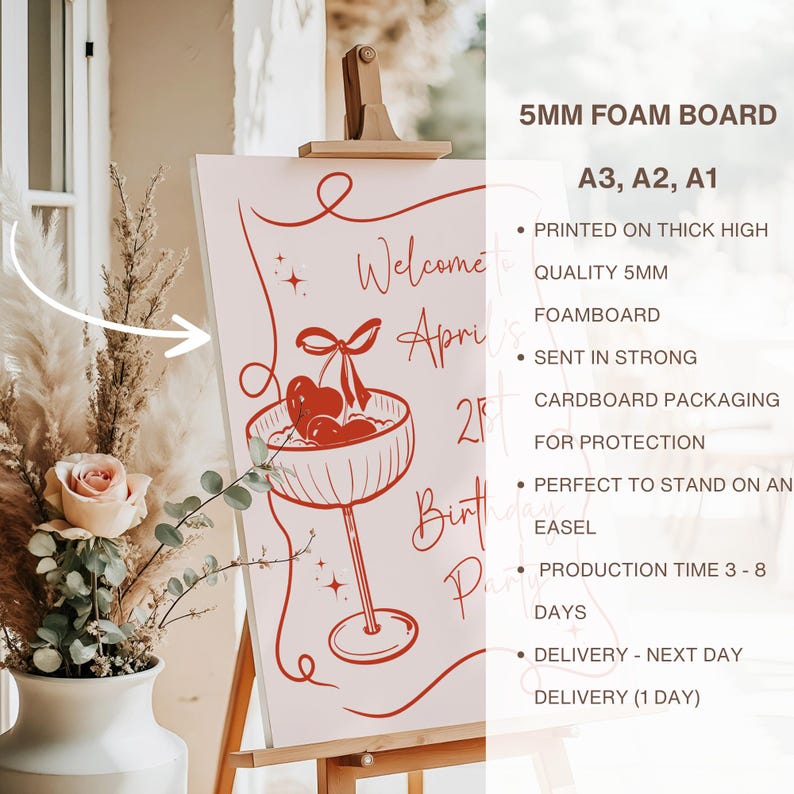 May include: A 5mm foam board sign featuring red line art of a cocktail glass with cherries and the text Welcome to April's 21st Birthday Party. The board is displayed on a wooden easel next to a vase with dried flowers and a pink rose.