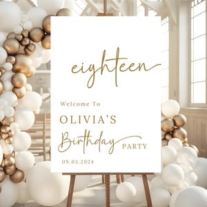 May include: White sign with gold lettering announcing an 18th birthday party for Olivia. The sign reads "eighteen", "Welcome to Olivia's Birthday Party", and "09.03.2024".