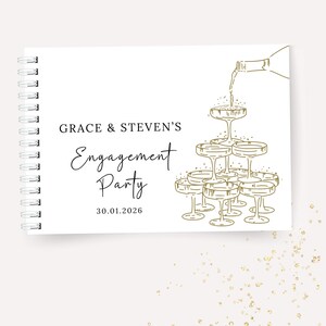 K&ouml;nnte beinhalten: Wei&szlig;es Spiralnotizbuch mit goldenem Text und Illustrationen. Auf dem Cover steht "GRACE & STEVEN'S Engagement Party" mit dem Datum 30.01.2026. Rechts ist eine Champagnerturm-Illustration abgebildet.