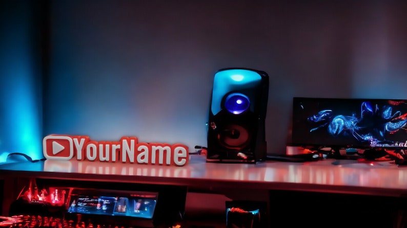 Puede incluir: Un logotipo de YouTube rojo y blanco con el texto "YourName" en un escritorio con un altavoz negro y un monitor de computadora con un dise&ntilde;o abstracto azul y negro.