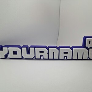 May include: A purple and white plastic nameplate with the text "YOURNAME" and a purple Twitch logo.