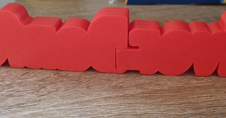 Puede incluir: Letras de espuma roja que deletrean la palabra "LOVE" en un estilo audaz y tridimensional. Las letras est&aacute;n unidas, creando una palabra continua.