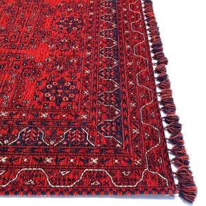 Pu&ograve; includere: Tappeto rosso e blu con motivi e frange sui bordi. Il tappeto ha un design tradizionale con dettagli intricati.