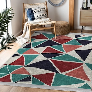 May include: A geometric patterned rug with a white background and a design of teal, red, and navy blue triangles. The rug has a fringe border.