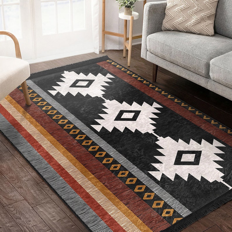 May include: A black and white geometric rug with a southwestern design. The rug has a fringed border and features a pattern of diamonds and triangles. The rug is on a wooden floor.