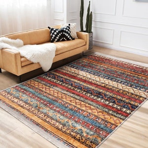 Hereke Motif Rug-A colorful, striped rug with a geometric pattern in shades of red, orange, blue, and yellow. The rug has a fringe border.