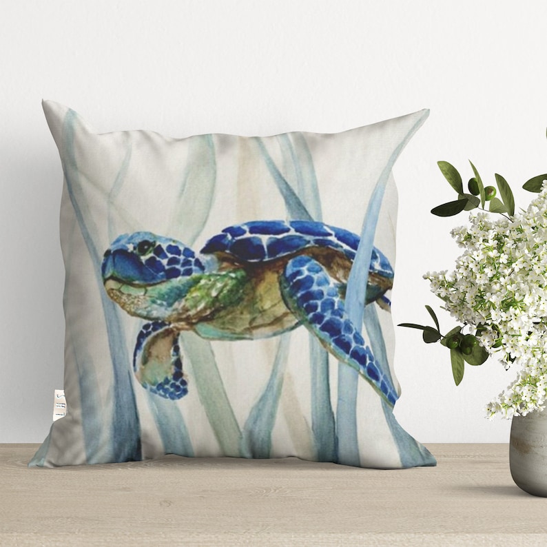 May include: A watercolor painting of a blue sea turtle swimming through a bed of seagrass. The turtle is painted in shades of blue and green, with a brown shell. The seagrass is painted in shades of blue and green.