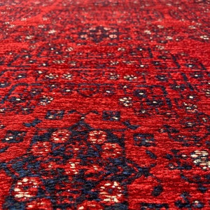 Pu&ograve; includere: Un tappeto rosso con un motivo blu e oro. Il tappeto ha un design persiano tradizionale.