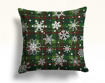 May include: Green and red plaid throw pillow with a white snowflake pattern.