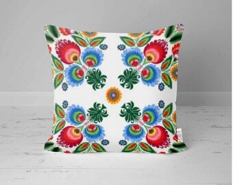 May include: A white pillow with a colorful floral pattern. The flowers are red, blue, green, yellow, and orange. The pattern is symmetrical and repeats across the pillow.