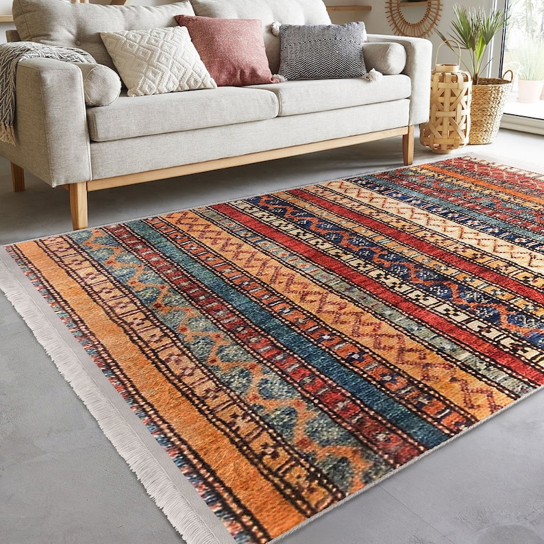 Hereke Motif Rug-A colorful, striped rug with a geometric pattern in shades of red, orange, blue, and yellow. The rug has a fringe border.