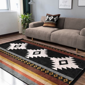 May include: Black and white geometric rug with a brown, orange and red striped border. The rug has a southwestern design with diamond shapes and a black background.