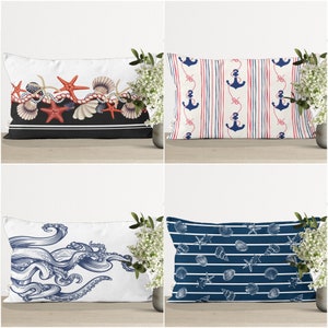 Pode incluir: Quatro almofadas decorativas com temas náuticos. As almofadas apresentam estrelas do mar vermelhas, âncoras azuis e conchas marinhas sobre um fundo branco.