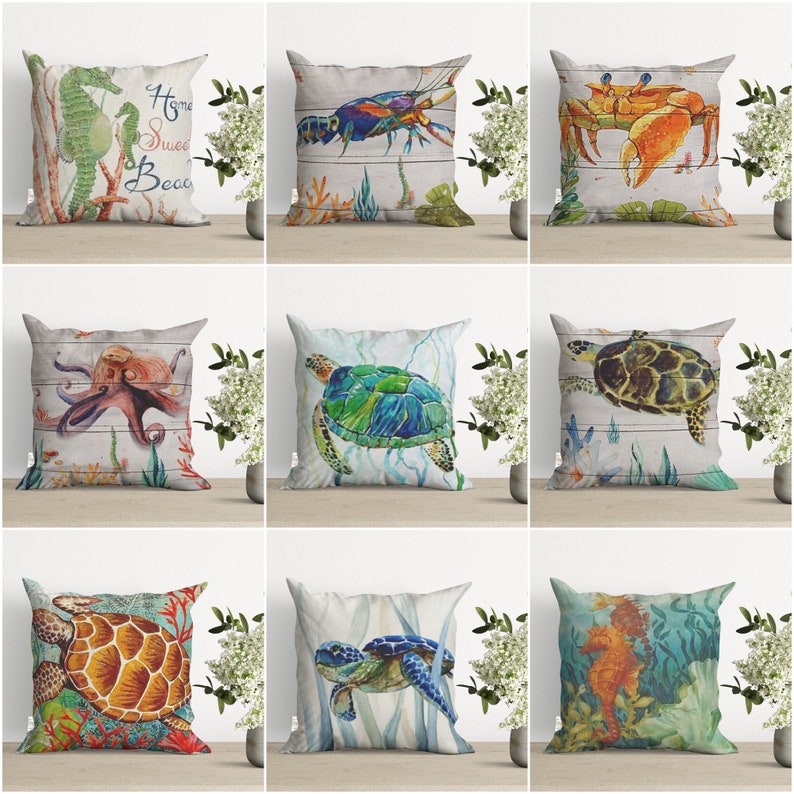 May include: Nine different pillow designs featuring various sea creatures, including a seahorse, crab, octopus, and sea turtles. The pillows are all on a light wood surface with a white background.
