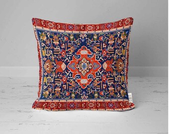 May include: A decorative cushion featuring a red, blue and white patterned design. The pattern is reminiscent of a traditional Persian rug.