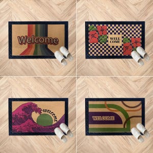 Könnte beinhalten: Vier rechteckige Fußmatten mit unterschiedlichen Designs. Eine hat das Wort "Welcome" in einem Retro-Schriftzug mit einem Regenbogenstreifen-Design. Eine andere hat rote Blumen und die Worte "Well Come". Die dritte hat ein Wellenmuster und das Wort "Welcome". Die letzte hat das Wort "Welcome" mit grünen und braunen geschwungenen Linien.