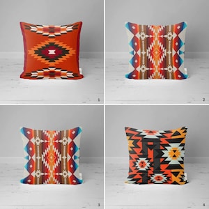 Op de afbeelding: Vier decoratieve kussens met geometrische patronen in tinten rood, oranje, blauw, zwart en wit. De kussens zijn gerangschikt in een rasterpatroon op een wit houten oppervlak.
