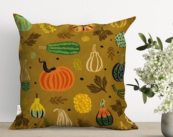 May include: A mustard yellow throw pillow with a repeating pattern of green, orange, and yellow gourds and leaves.
