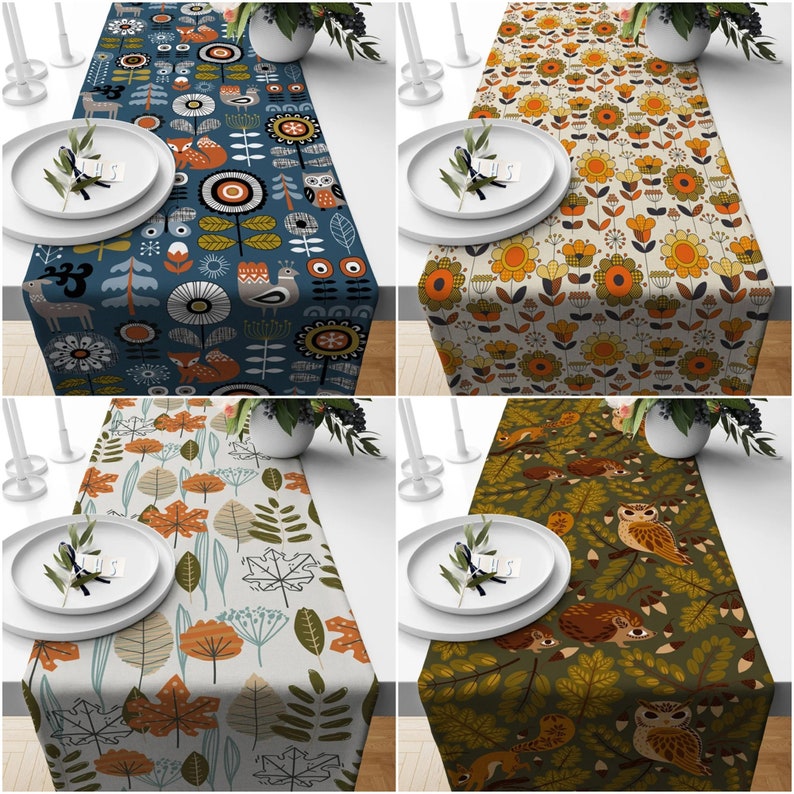 May include: Four table runners with nature-themed designs. One is navy blue with foxes, deer, and owls. Another is beige with orange and yellow flowers. The third is light beige with autumn leaves. The last is olive green with owls and squirrels.