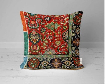 May include: A red, green and black patterned throw pillow with a floral design. The pillow is made of fabric and has a square shape.