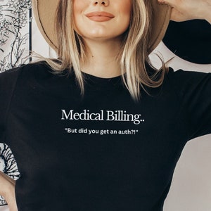 以下が含まれることがあります： 白い文字で「Medical Billing... "But did you get an auth?"」と書かれた黒いTシャツ