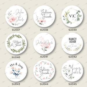 Op de afbeelding: Een set van 10 ronde bruiloftfavorieten stickers met verschillende bloemenontwerpen en namen. De stickers hebben een witte achtergrond met groene en roze bloemenillustraties en tekst. De tekst bevat namen zoals "Julian & Jacob", "Meyer & Jacob", "Mia & Jame" en "Nancy Adam".