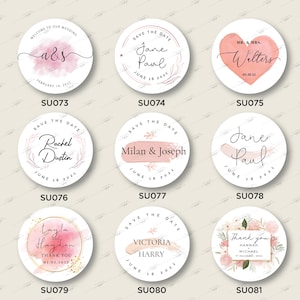 Op de afbeelding: Tien ronde huwelijkstickers met verschillende ontwerpen. De stickers hebben aquarel achtergronden, bloemenillustraties en tekst zoals "Save the Date", "Welkom op onze bruiloft" en "Bedankt".