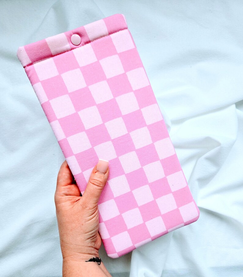 Puede incluir: Bolsa de tela a cuadros rosa y blanca con cierre de presi&oacute;n.
