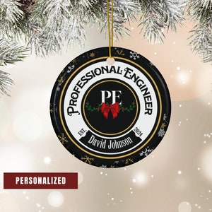May include: A black and white Christmas ornament with a gold rim and snowflakes. The ornament features the text "Professional Engineer" with the letters "PE" in a circle with a red bow. The text "Est. 2024" and "David Johnson" are also included.