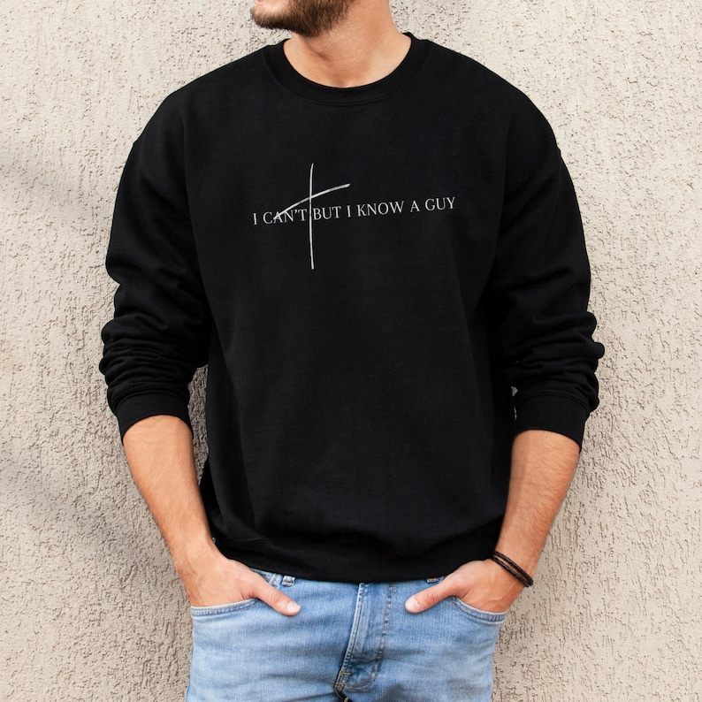May include: A black sweatshirt with a white graphic that says "I can't but I know a guy" with a stylized cross.