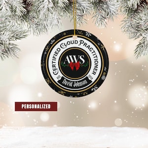 May include: A black and gold round Christmas ornament with the text "CERTIFIED CLOUD PRACTITIONER" and "AWS" with a red bow. The ornament also includes the name "David Johnson" and the year "2024". The word "PERSONALIZED" is displayed.