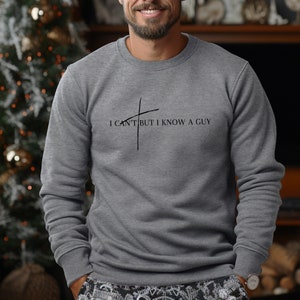 May include: A gray sweatshirt with the text "I can't but I know a guy" and a cross graphic.