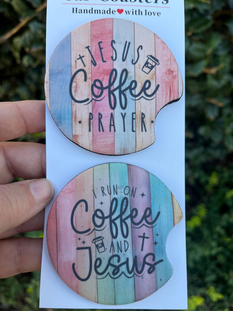 May include: Two round, colorful, wooden coasters with a white background. The top coaster has the text "Jesus Coffee Prayer" with a coffee cup icon. The bottom coaster has the text "I run on Coffee and Jesus" with a coffee cup icon and a cross.