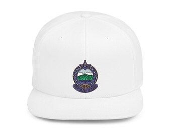May include: White baseball cap featuring an embroidered emblem with a mountain landscape in green, blue, and white. The emblem is surrounded by a decorative border in purple and gold. The cap has a flat brim and a structured fit.