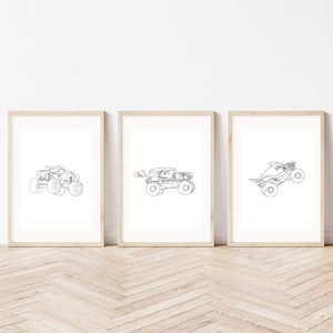 Könnte beinhalten: Drei gerahmte Drucke mit Strichzeichnungen von Monstertrucks. Die Trucks sind in einem minimalistischen Stil mit schwarzen Linien auf weißem Hintergrund dargestellt. Die Rahmen sind hellholzfarben, und die Drucke werden auf einem hellen Holzboden präsentiert.