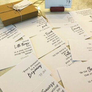May include: A collection of white cards with inspirational quotes printed in black. The quotes include "Don't be afraid to give up the good to go for the great", "A friend is someone who knows all about you and still loves you", "Every moment is a fresh beginning", "Doing little things well is a step toward doing big things better", "The art of knowing is knowing what to ignore", "All the world is made of faith, love and pixie dust", "Be the change that you wish to see in the world", and "Our face always the sunshine shadows will fall behind you".