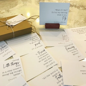 May include: A collection of inspirational quote cards with white backgrounds and black text. The cards feature quotes about friendship, love, and life. Some of the quotes include "Don't be afraid to give up the good to go for the great" and "Love betters what is best."