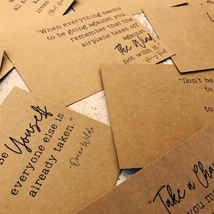 May include: A collection of inspirational quotes printed on brown paper cards. The quotes include "Be yourself, everyone else is already taken." by Oscar Wilde, "When everything seems to be going against you, remember that the airplane takes off against the wind, not with it." by Henry Ford, and "Don't be afraid to give up the good to go for the great."