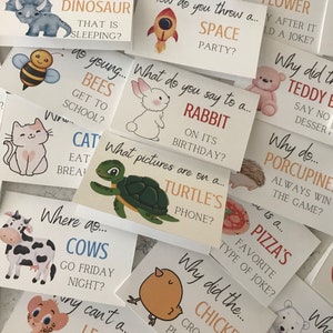 May include: A set of colourful cards with illustrations of animals and objects. Each card has a question written on it, such as "What do you say to a rabbit?" and "Why did the chicken cross the road?"