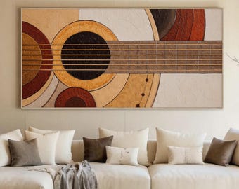 Könnte beinhalten: Abstraktes Gitarrenbild mit geometrischem Design. Das Kunstwerk zeigt ein großes, kreisförmiges Schallloch und Saiten, mit einer Farbpalette aus Beige, Braun und Rot. Das Gemälde ist gerahmt und hängt über einem weißen Sofa.