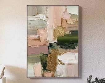 Puede incluir: Pintura abstracta con marco plateado. La obra presenta pinceladas texturizadas en tonos rosa, verde, dorado y blanco. La pintura se exhibe en una pared de color neutro, con una escultura minimalista y una mesa con jarrones en primer plano.