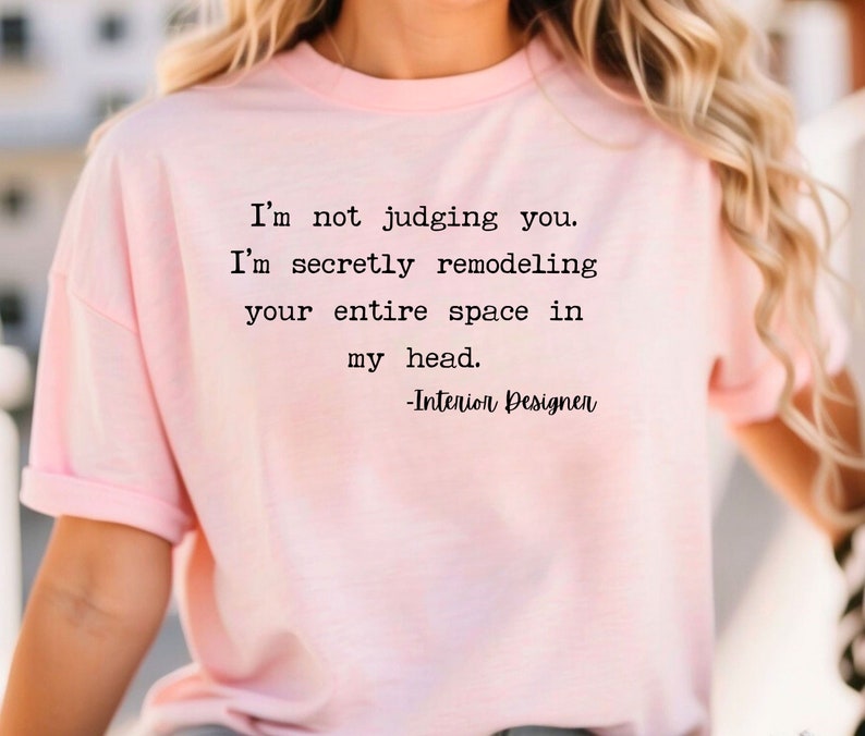 K&ouml;nnte beinhalten: Ein pinkfarbenes T-Shirt mit einem lustigen Zitat &uuml;ber Innenarchitektur. Der Text lautet: "Ich beurteile dich nicht. Ich renoviere heimlich deinen gesamten Raum in meinem Kopf. -Innenarchitekt"