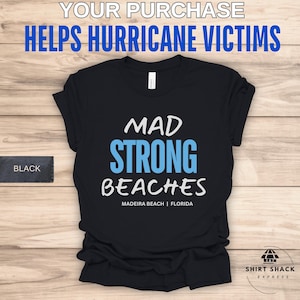 May include: Black t-shirt with white text that reads "Mad Strong Beaches Madeira Beach | Florida". The text "Strong" is in blue.
