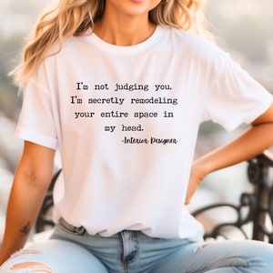 K&ouml;nnte beinhalten: Ein wei&szlig;es T-Shirt mit einem schwarzen Text-Motiv, auf dem steht: "Ich verurteile dich nicht. Ich renoviere heimlich deinen gesamten Raum in meinem Kopf. -Innenarchitekt"